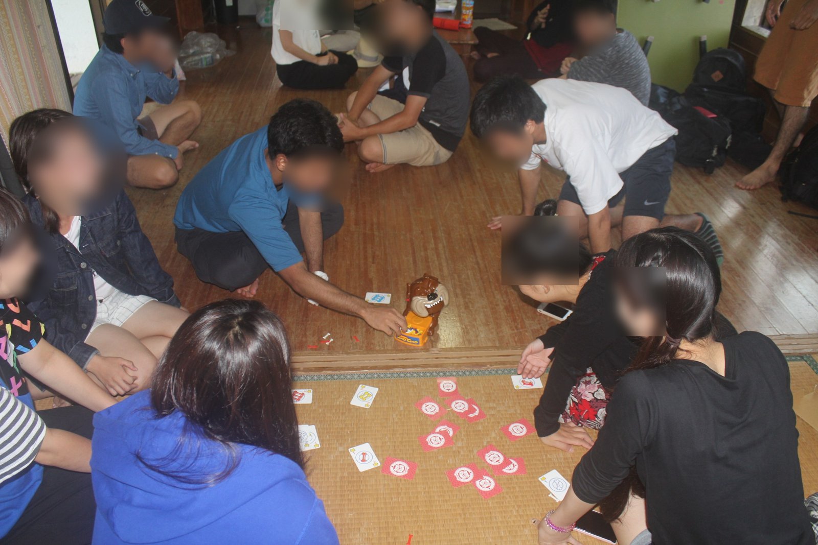 床にカードを広げて大人数で遊んでいる